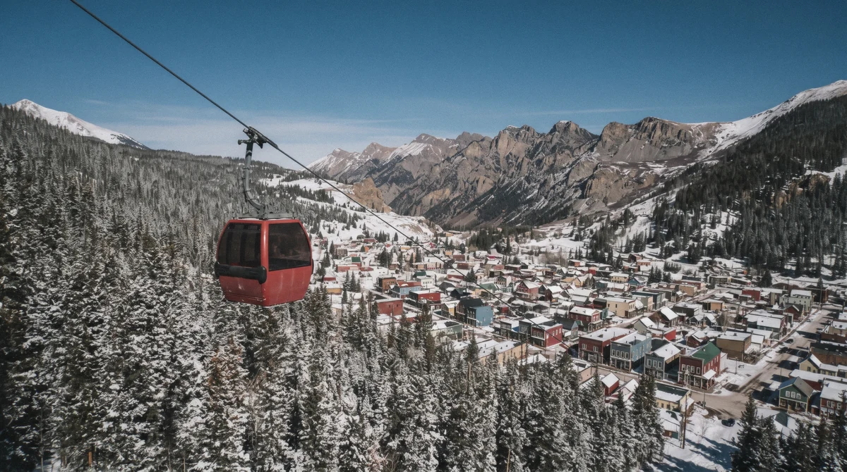 The free BreckConnect gondola rising over the Victorian town, the link between Breckenridge lodging and the ski-in ski-out bases