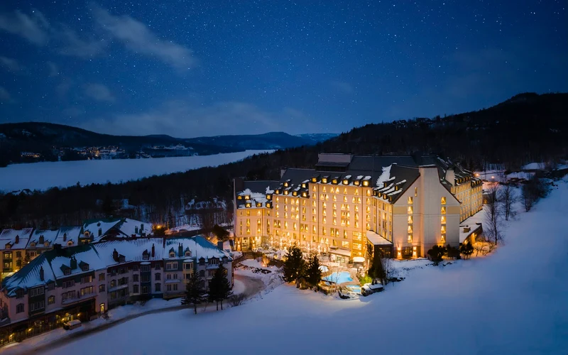 The Fairmont Tremblant on the shoulder above Place Saint-Bernard, a ski-in ski-out hotel at Mont-Tremblant, Quebec
