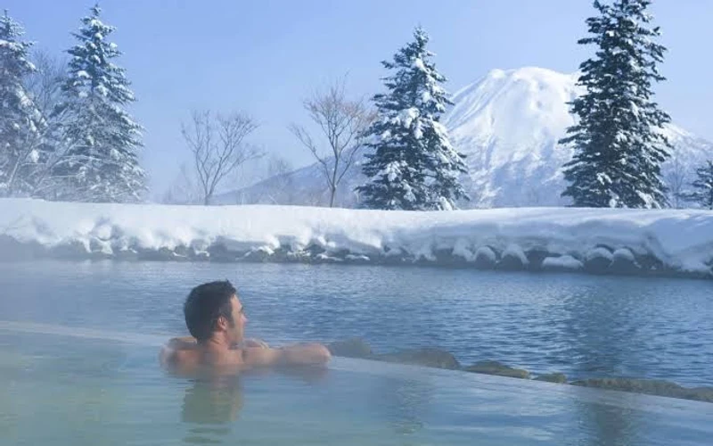Hilton Niseko Village sitting on the Niseko Gondola base with Mount Yotei behind, a ski-in ski-out hotel in Niseko